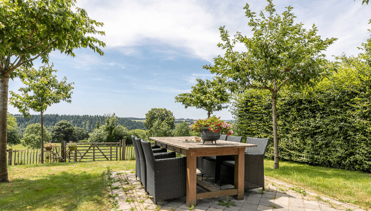 Table et chaises sur la terrasse, vue sur la vallée verdoyante