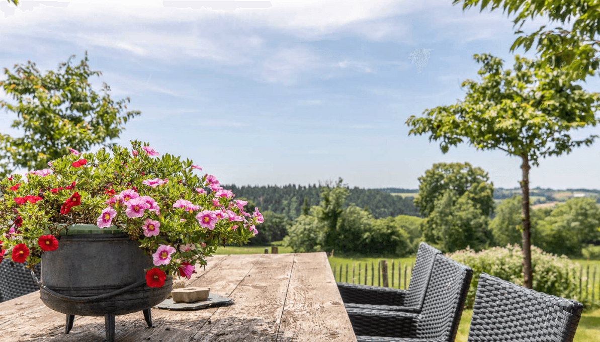 Repas en plein air sur pavés, jardin arboré et vue lointaine